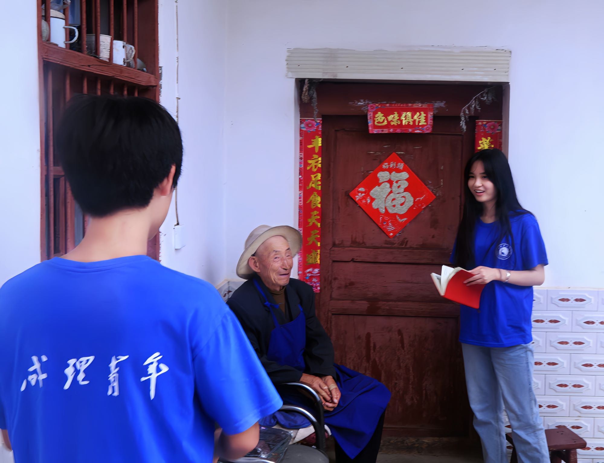 圖為團隊成員拜訪采訪當地老教師并向其贈送衣物。張世玉 供圖